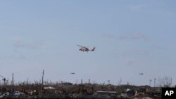 US Coast Guards helicopters fly over Marsh Harbor after it was devastated by Hurricane Dorian on Abaco Island, Bahamas, Sept. 8, 2019. 