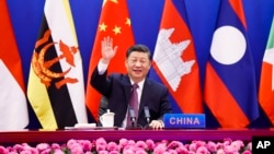 In this photo released by Xinhua News Agency, Chinese President Xi Jinping waves as he chairs the ASEAN-China Special Summit to commemorate the 30th Anniversary of ASEAN-China Dialogue Relations via video link from Beijing, China on Monday, Nov. 22, 2021.