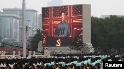 FILE - Chinese President Xi Jinping is seen on a giant screen as he delivers a speech at the event marking the 100th founding anniversary of the Communist Party of China, on Tiananmen Square in Beijing, China, July 1, 2021. 