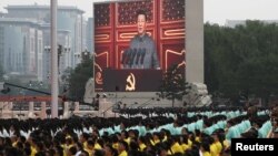 FILE - Chinese President Xi Jinping is seen on a giant screen as he delivers a speech at the event marking the 100th founding anniversary of the Communist Party of China, on Tiananmen Square in Beijing, China, July 1, 2021. 