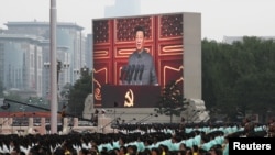 FILE - Chinese President Xi Jinping is seen on a giant screen as he delivers a speech at the event marking the 100th founding anniversary of the Communist Party of China, on Tiananmen Square in Beijing, July 1, 2021. 