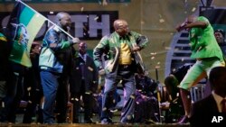 The ruling party president Jacob Zuma, center, sings and dances, at a victory party downtown Johannesburg, South Africa, following the announcement of the results for the 2014 national election result Saturday May 10, 2014