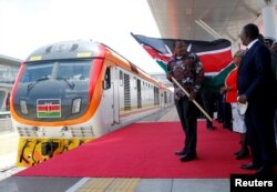 FILE - Kenya's President Uhuru Kenyatta flags off the train linking Nairobi and Naivasha at the Nairobi Terminus on the outskirts of Nairobi, Oct. 16, 2019.