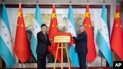 En esta foto de la Agencia de Noticias Xinhua, el Canciller de China, Qin Gang, a la izquierda, y su homólogo hondureño, Enrique Reina, revelan la placa de la Embajada de Honduras durante la inauguración de la misión en Beijing, el 11 de junio de 2023.