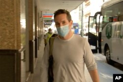 FILE - Australian Broadcasting Corp. journalist Bill Birtles walks into a hotel for quarantine in Sydney, Australia, Sept. 8, 2020.
