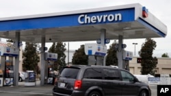 ARCHIVO - Un automovilista conduce cerca de las bombas en una gasolinera Chevron en Oakland, California. (Foto AP/Ben Margot)