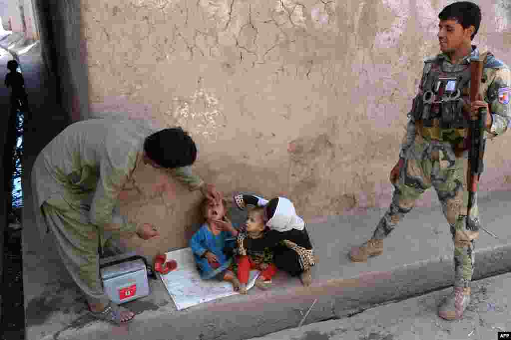 Seorang petugas kesehatan Afghanistan memberikan vaksinasi polio terhadap seorang anak di Surkh Rod, provinsi Nangarhar.