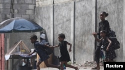 Seorang perempuan dan ketiga anaknya melarikan diri dari rumah mereka akibat kekerasan geng bersenjata di Port-au-Prince, Haiti, pada 20 Oktober 2024. (Foto: Reuters/Ralph Tedy Erol)