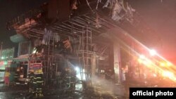 အလုံမြို့နယ်က ထူးစက်သုံးဆီအရောင်းဆိုင် ပေါက်ကွဲမီးလောင်ပြီး ငြှိမ်းသတ်နေတဲ့ မီးသတ်တပ်ဖွဲ့ဝင်များ။ (ဇန်နဝါရီ ၁၆၊ ၂၀၂၂။ ဓာတ်ပုံ - Myanmar Fire Services Department)