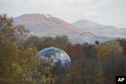 Un globo y una rueda moscovita se aprecian en un bosque cerca de Bonn, en Alemania, donde se lleva a cabo la Conferencia Marco de la Convención de la ONU sobre el Cambio Climático, hasta el 17 de noviembre.