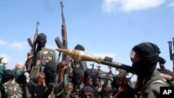 FILE - Armed al-Shabab fighters ride on pickup trucks as they prepare to travel into the city, just outside the capital Mogadishu, in Somalia on December 8, 2008.