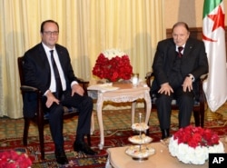 FILE - French President Francois Hollande, left, and Algerian President Abdelaziz Bouteflika, right, pose prior to a meeting in Algiers, June 15, 2015.