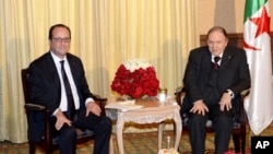 FILE - French President Francois Hollande, left, and Algerian President Abdelaziz Bouteflika, right, pose prior to a meeting in Algiers, June 15, 2015.