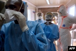 Medical staff of International Medical Corps put on Personal Protective Equipment at the isolation ward of Ministry of Health Infectious Disease Unit in Juba, South Sudan, on April 24, 2020.