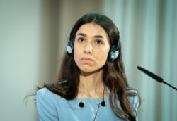 FILE - Nobel Peace Prize laureate and Yazidi activist Nadia Murad listens during a symbolical start of the lectures "Women, Peace and Security" in Berlin, Germany, May 7, 2021.