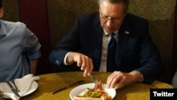 Republican presidential hopeful John Kasich is seen eating pizza with a fork in this photo posted on Twitter. (Twitter)