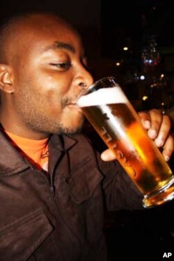 Webster Dladla swigs a beer at his favorite drinking hole in Johannesburg....He has tickets for the South Africa-Uruguay game.....
