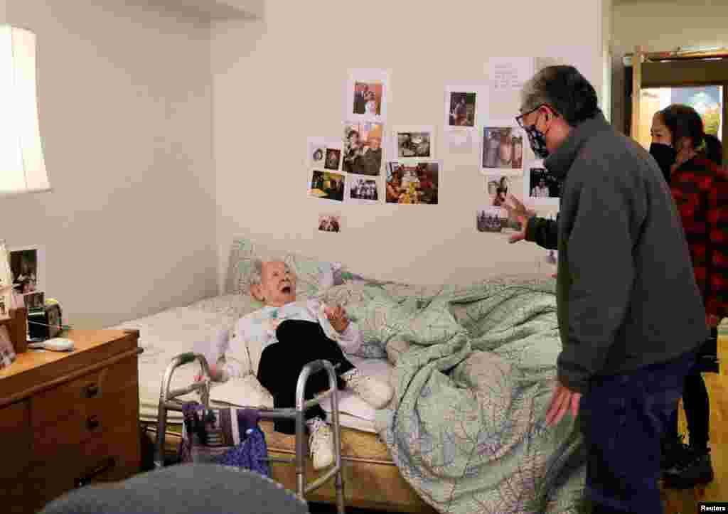 Yoshia Uomoto, 98, reacts as her son Mark Uomoto and niece Gail Yamada surprise her with their first in-person visit in a year after indoor visitation restrictions due to the COVID-19 were lifted at Nikkei Manor, an assisted living facility in Seattle, Washington, March 30, 2021.