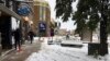 Personas limpian las calles tras una tormenta otoñal de nieve en Helena, Montana, el miércoles 9 de octubre del 2019. (AP Foto/Matt Volz).