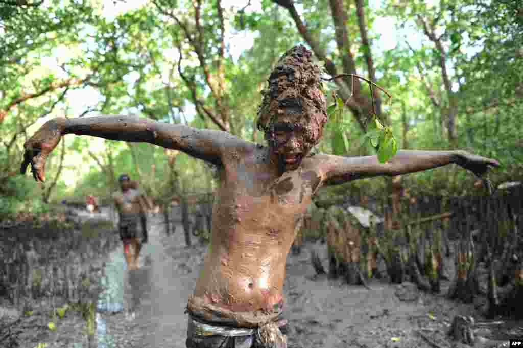 A Balinese boy puts mud on his body during a traditional mud baths known as Mebuug-buugan, in Kedonganan village, near Denpasar on Indonesia&#39;s resort island of Bali, Indonesia.