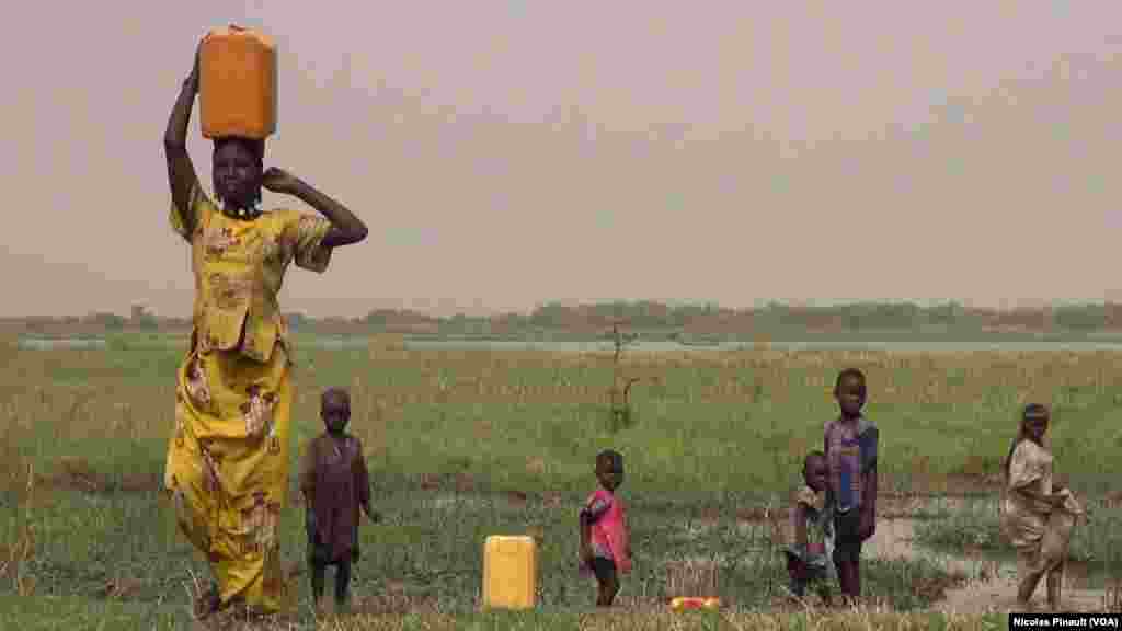 Une jeune femme porte un bidon d&#39;eau au bord du lac Tchad, Tagal, Tchad, le 24 avril 2017 (VOA/Nicolas Pinault)