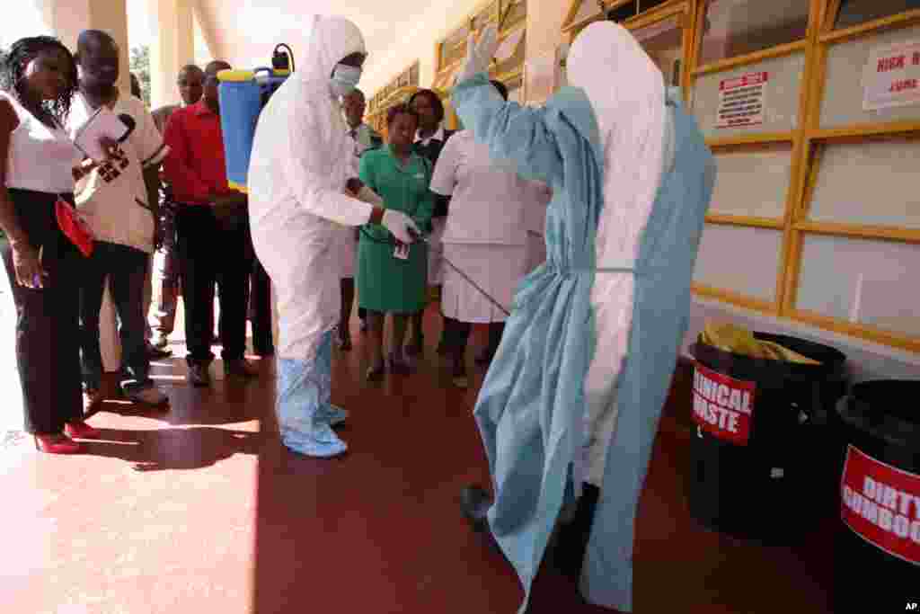 A nurse is sprayed during a tour of one of the Ebola Centers in Harare, Zimbabwe, Sept. 23, 2014.
