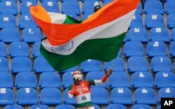 FILE - An Indian cricket fan waves the tricolored national flag after India's win over Sri Lanka in the third cricket test match in Pallekele, Sri Lanka, Aug. 14, 2017. Desecrating India's flag is punishable by up to three years in prison.
