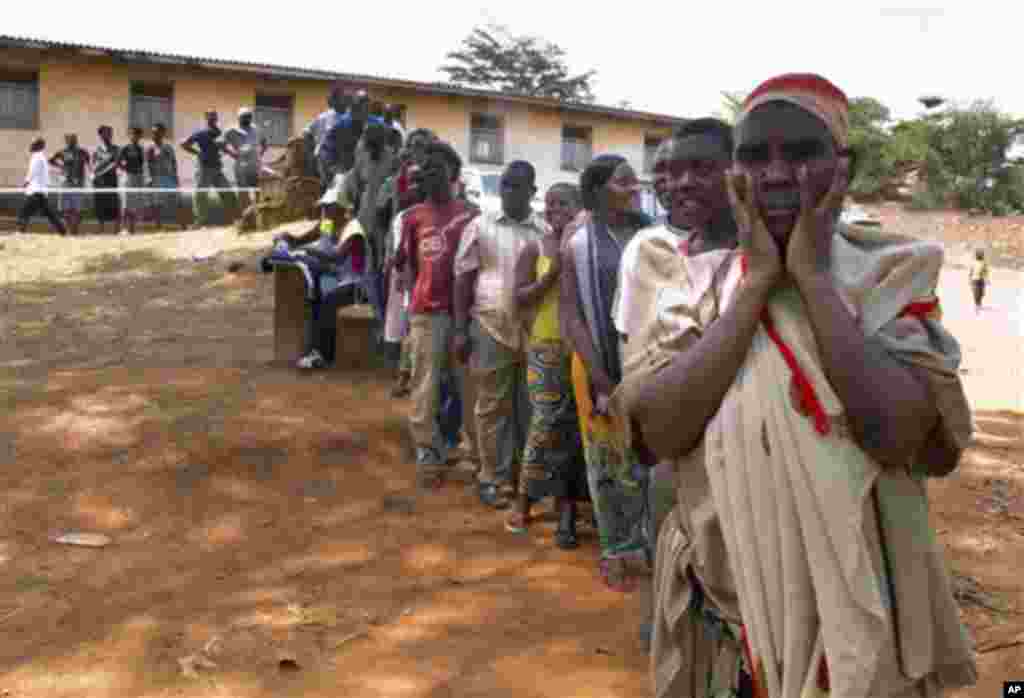 People wait in queue to vote at the Mango polling station in Kampala, Uganda, Friday, Feb.18, 2011. Voters in Uganda on Friday had to choose between extending their president's 25-year grip on power or joining the anti-incumbent wave sweeping Africa and t