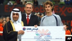 Ali Shareef Al-Emadi, PDG de Qatar National Bank, à gauche, et Alex Doods, président et directeur général d'ExxonMobile Qatar, à droite, remettent un chèque au britannique Andy Murray, vainqueur de l'épreuve de la finale de l’Open du tournoi de tennis de Qatar, à Doha, 5 janvier 2008.