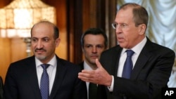 Menteri Luar Negeri Rusia Sergey Lavrov (kanan) menyambut Ahmad Jarba, pemimpin delegasi Koalisi Nasional Suriah di Moskow (4/2). (AP/Alexander Zemlianichenko)