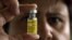 FILE - A nurse displays a vial of vaccine in Brasilia, Brazil.