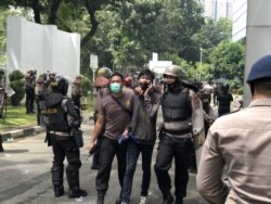 Seorang pemuda yang diamankan polisi terkait unjuk rasa berujung anarkis di gedung DPRD Sumut, Kota Medan, Kamis 8 Oktober 2020. (VOA/Anugrah Andriansyah)