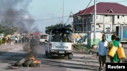 FILE - Peacekeepers serving in the United Nations Organization Stabilization Mission in the Democratic Republic of the Congo (MONUSCO) drive past burning tyres during protests against President Joseph Kabila in the Democratic Republic of Congo's capital Kinshasa, April 10, 2017.