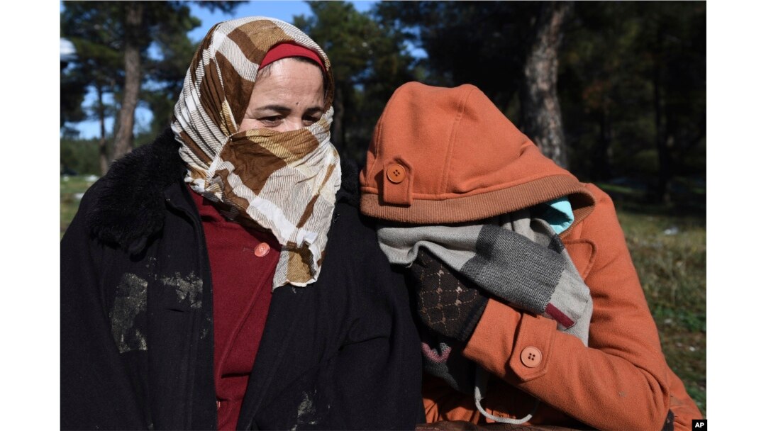 Syrian refugees shelter from the cold weather on the outskirts of the northern Greek city of Thessaloniki, Nov. 30, 2016.
