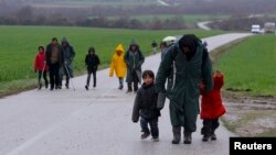 Migrants walk along a road from the village of Chamilo to the migrant camp at the village of Idomeni, near the Greek-Macedonian border, Greece, March 15, 2016.