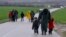 Migrants walk along a road from the village of Chamilo to the migrant camp at the village of Idomeni, near the Greek-Macedonian border, Greece, March 15, 2016.
