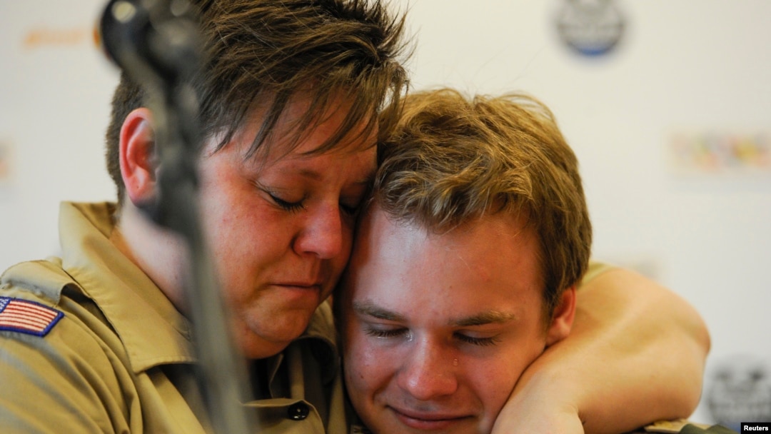 Jennifer Tyrrell (kiri), yang dipecat dari Pramuka AS karena ia gay, memeluk Pascal Tessier, 16, setelah munculnya keputusan pencabutan larangan anak laki-laki gay menjadi anggota Boy Scouts of America (24/5). (Reuters/Michael Prengler)