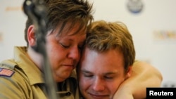 Jennifer Tyrrell (kiri), yang dipecat dari Pramuka AS karena ia gay, memeluk Pascal Tessier, 16, setelah munculnya keputusan pencabutan larangan anak laki-laki gay menjadi anggota Boy Scouts of America (24/5). (Reuters/Michael Prengler)