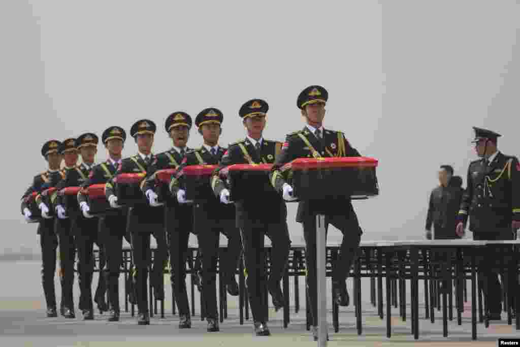 Chinese honor guards carry caskets returned by South Korea containing the remains of Chinese soldiers who were killed during the 1950-53 Korean War, at an airport in Shenyang, Liaoning province.