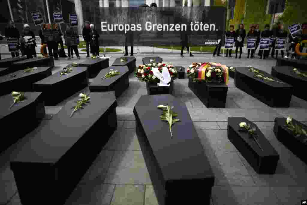 Paperboard caskets are on display in front of the chancellery during protest of the civil society group 'Campact' against European refugee policy in Berlin, Germany. The main banner reads: 'European borders kill.'