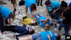 Protesters stage a die-in and have their shapes traced on the sidewalk outside the courthouse where the Purdue Pharma bankruptcy is taking place in White Plains, NY, Aug. 9, 2021.