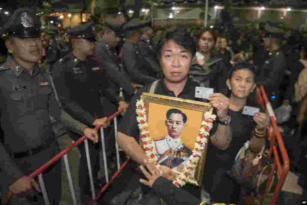 25일 태국 방콕에서 푸미폰 아둔야뎃 전 태국 국왕의 장례식이 치러졌다. 푸미폰 전 국왕의 초상화를 든 행렬이 화장식에 참석하기 위해 줄을 서 있다.