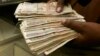 Currency dealer counts Kenya shillings at a money exchange counter, Nairobi, Oct. 23, 2008.