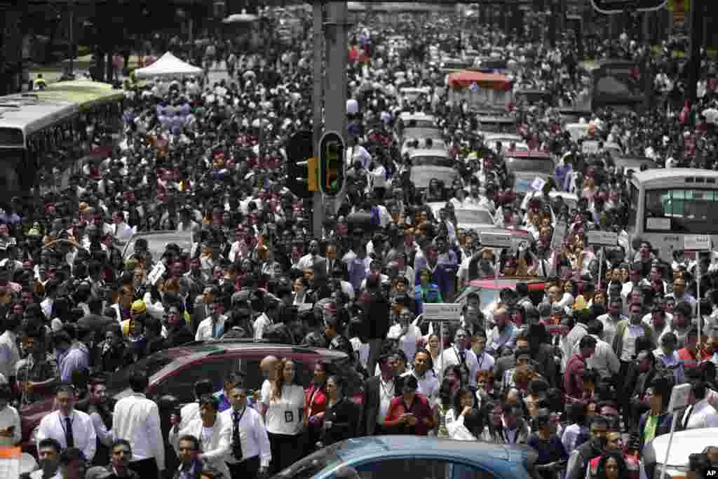 People evacuated from office buildings gather in Reforma Avenue after an earthquake in Mexico City, Sept. 19, 2017.