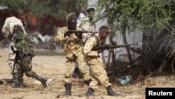 Somali government soldiers open fire during ambush by al-Shabaab rebels on the outskirts of Elasha town, May 29, 2012.