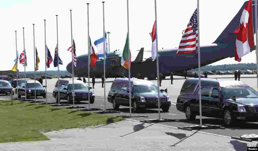 Đoàn xe tang đưa quan tài các nạn nhân chuyến bay MH17 chạy ngang qua quốc kỳ các nước khi rời sân bay Eindhoven để đến căn cứ quân sự ở Hilversum, Hà Lan, 23/7/14