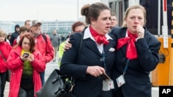 People react as they walk away from Brussels airport after explosions rocked the facility in Brussels, Belgium, March 22, 2016.