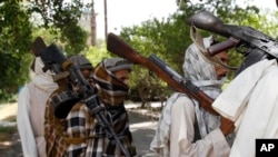 FILE - In this July 31, 2011 file photo, Taliban fighters hold their heavy and light weapons before surrendering them to Afghan authorities in Jalalabad, east of Kabul, Afghanistan. 