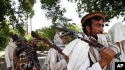 阿富汗喀布尔东部，塔利班战士们扛着武器准备向阿富汗当局投降。（资料图）