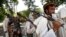 FILE - In this Sunday, July 31, 2011 file photo, Taliban fighters hold their heavy and light weapons before surrendering them to Afghan authorities in Jalalabad, east of Kabul, Afghanistan. 